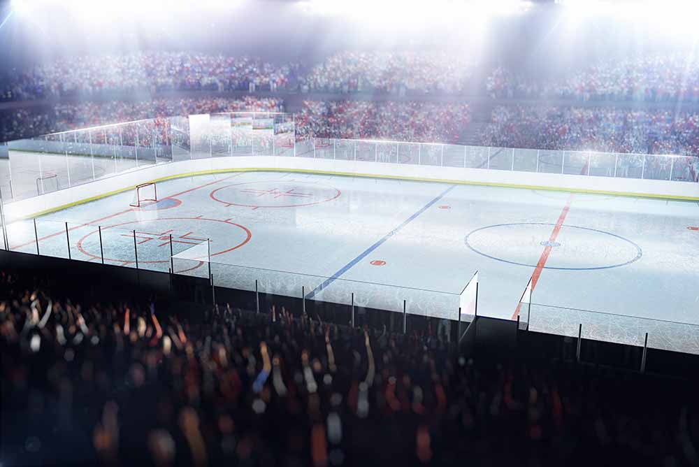 Osvětlené kluziště zimního stadionu s hokejovou arénou a diváky