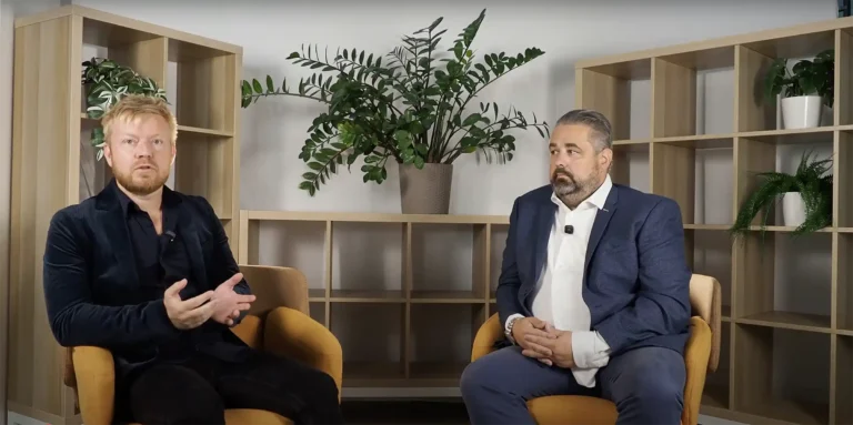 Lukáš Smelík a Tomáš Krejčí vedou rozhovor o digitalizaci výrobních dat v moderním interiéru s dřevěnými policemi a rostlinami v pozadí.