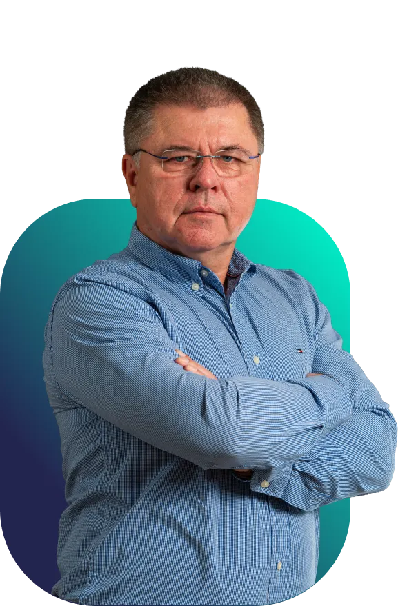 Libor Babák s rukama založenýma na hrudi v modré košili před tyrkysovo-modrým pozadím