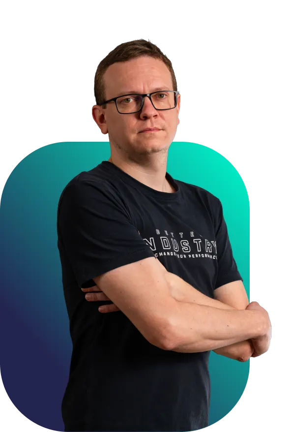 Patrik, oblíbený projektový manažer Better Industry, stojí v černém tričku s rukama založenýma na hrudi před tyrkysovo-modrým pozadím