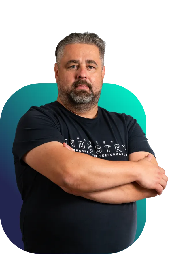 Tomáš, leader Better Industry v černém firemním tričku s rukama založenýma na hrudi před tyrkysovo-modrým pozadím“