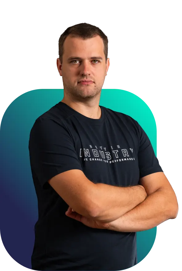 Zdenda, full‑stack programátor Better Industry v černém tričku s rukama založenýma na hrudi před tyrkysovo-modrým pozadím“