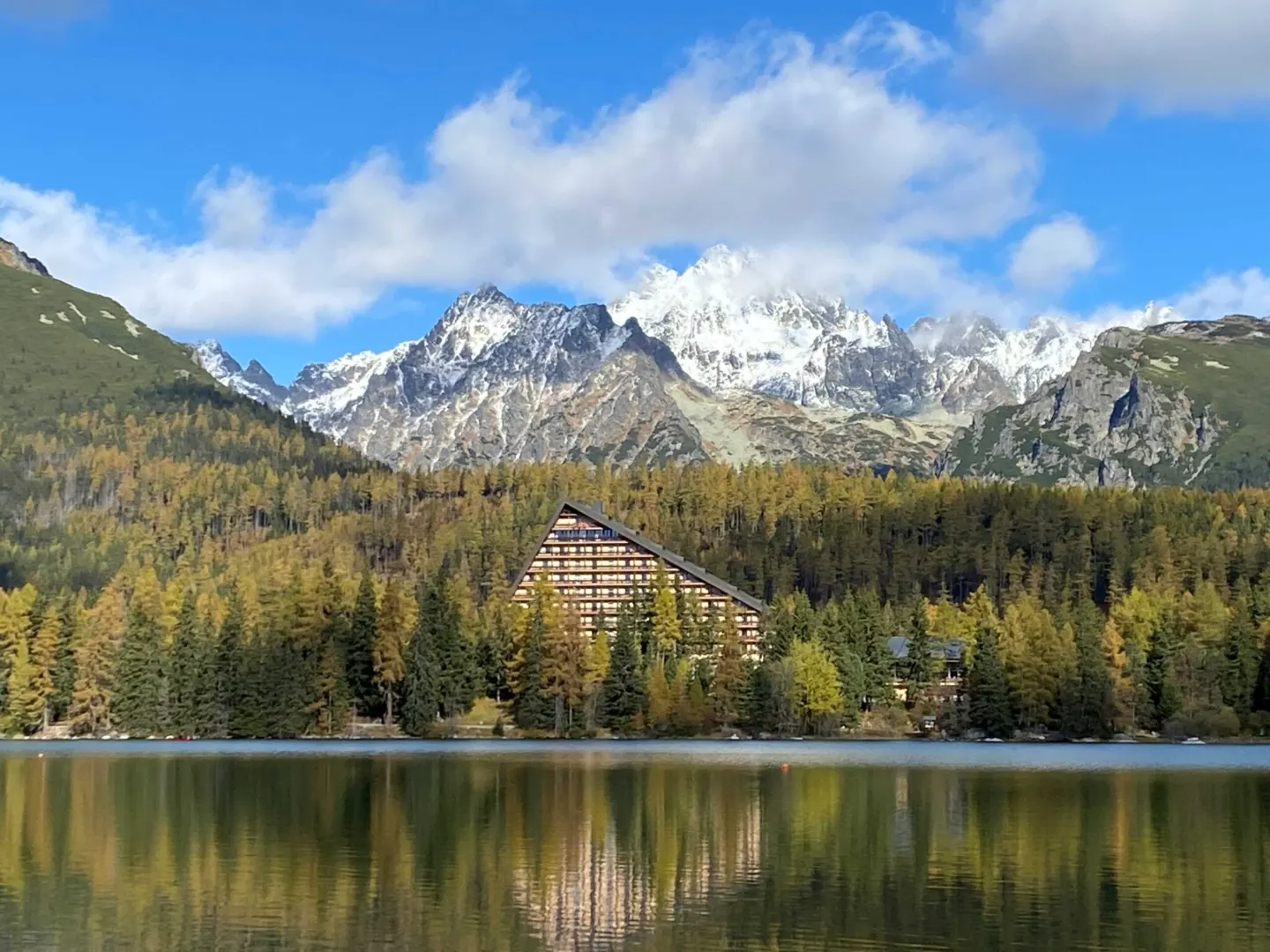 Hotel u Štrbského Plesa s výhledem na zasněžené vrcholy Vysokých Tater, místo konání odborné konference o údržbě.